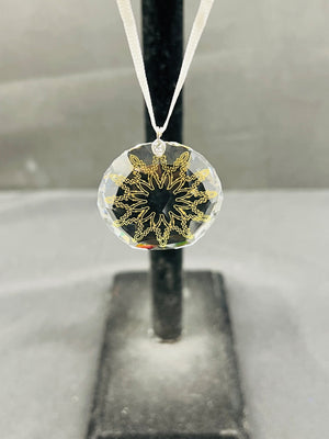 Decorative pendant with gold intricate design on a clear background