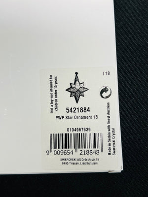 Close-up of a Swarovski crystal ornament label with product details.