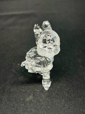 Clear glass figurine of a dragon on a black background