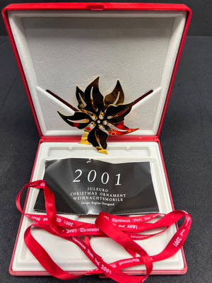 Christmas ornament with '2001' tag in an open red box on a black background