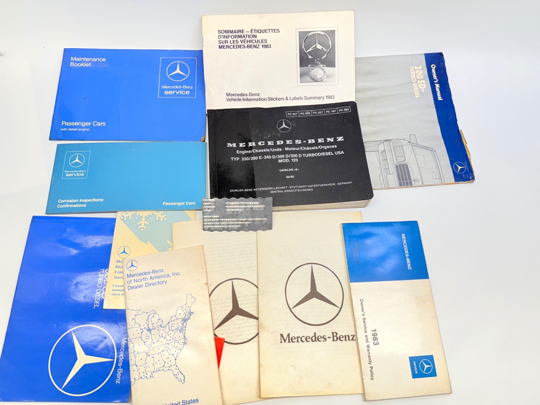 Collection of Mercedes-Benz service manuals and documents on a white background