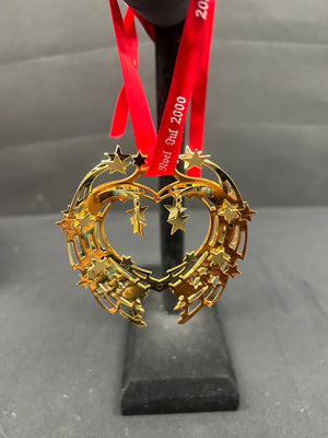 Gold star-shaped ornament on a stand with a red ribbon