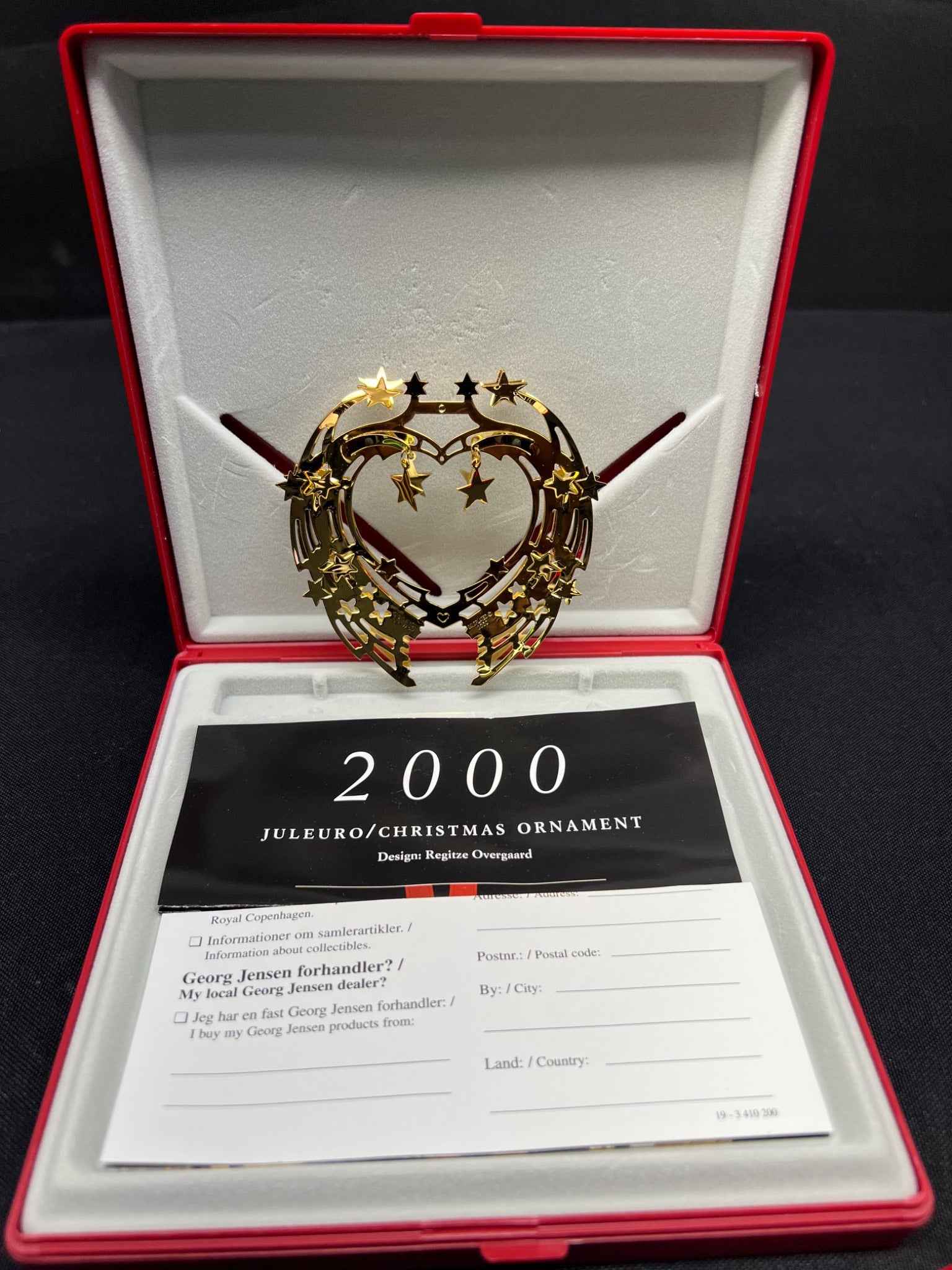 Decorative Christmas ornament in a red box with a card labeled '2000 Juleuge/Christmas Ornament'.