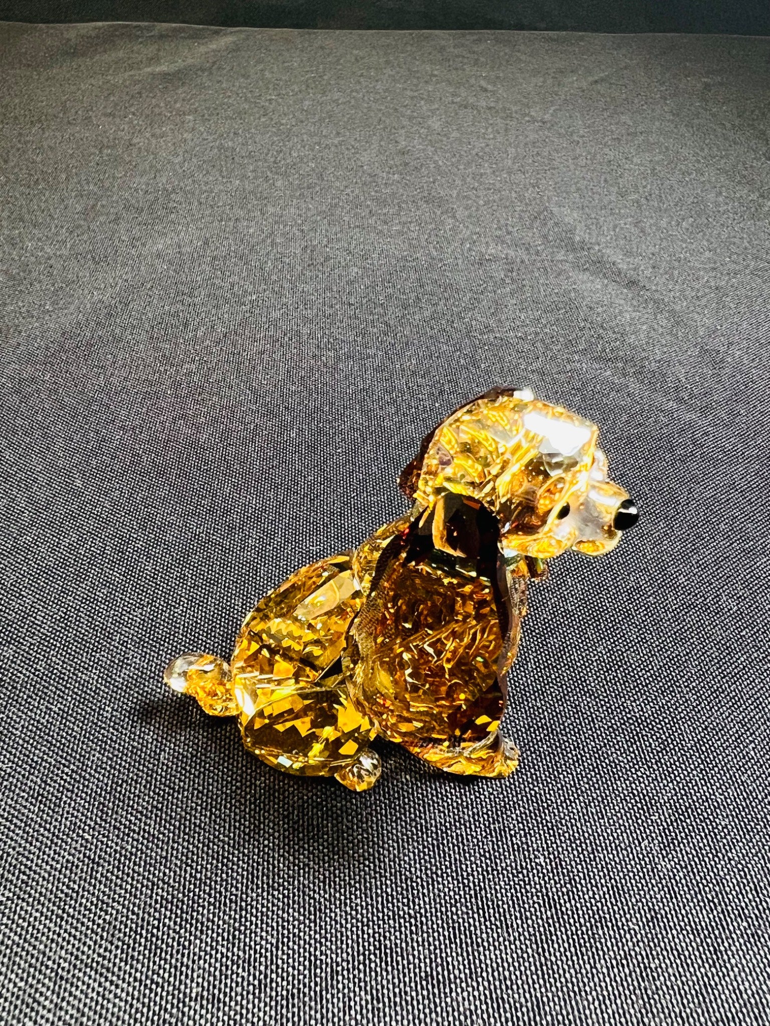 Crystal dog figurine on a gray fabric background
