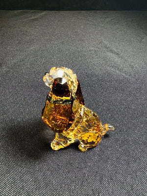 Crystal dog figurine on a gray fabric background