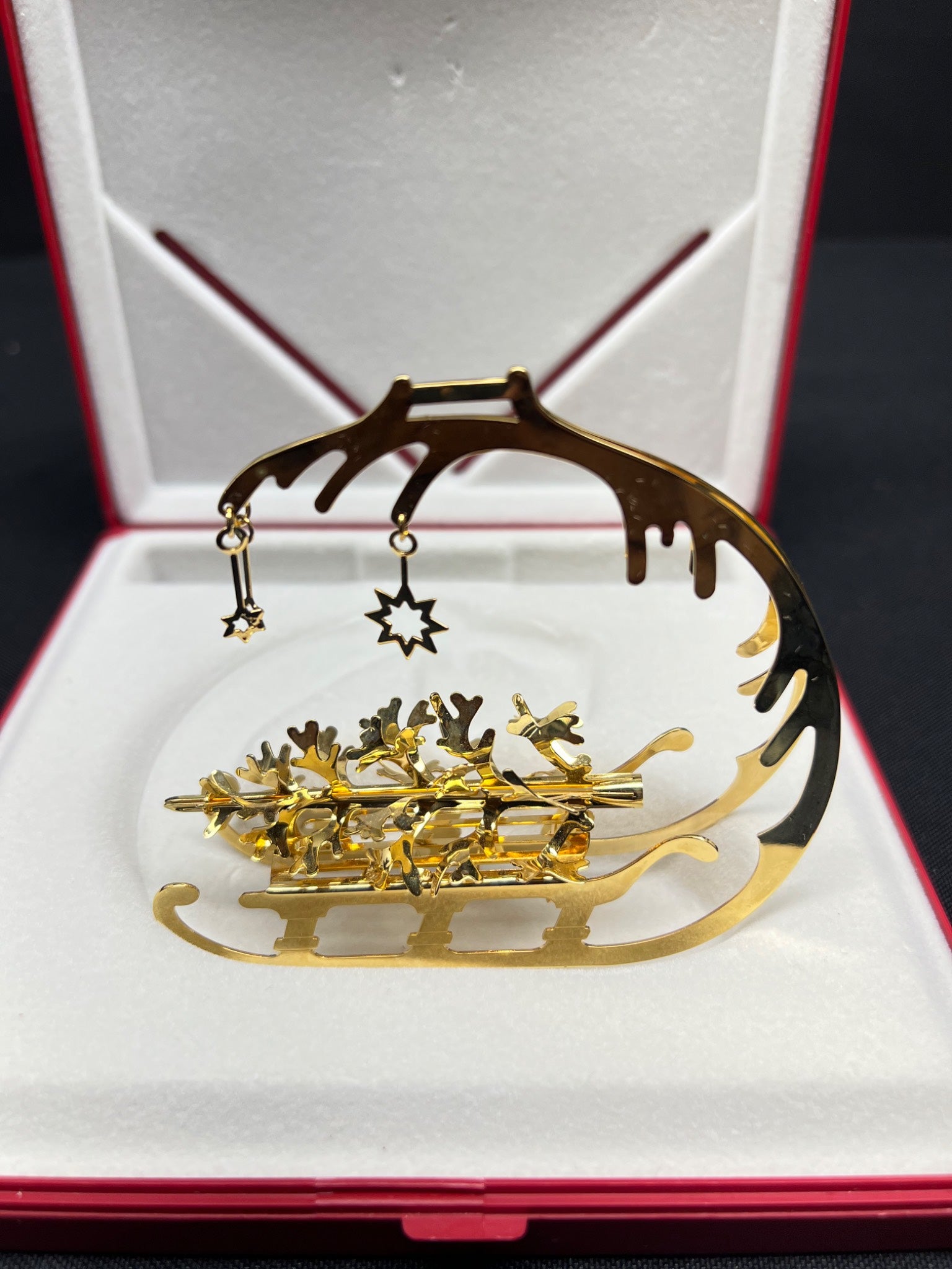 Set of gold hair pins with a star design on a decorative stand in an open jewelry box.