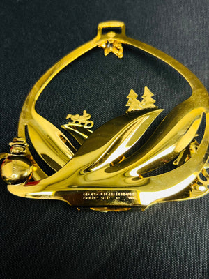 Gold decorative item with leaf design on a black background