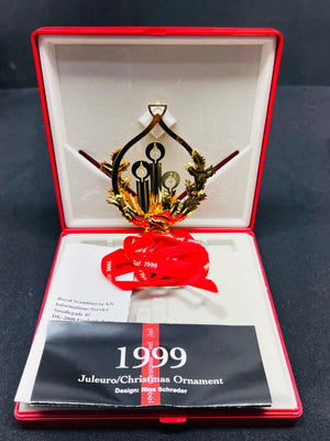 1999 Christmas ornament in a red and white box on a dark background
