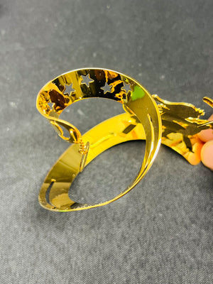 Gold bracelet with star designs on a gray background