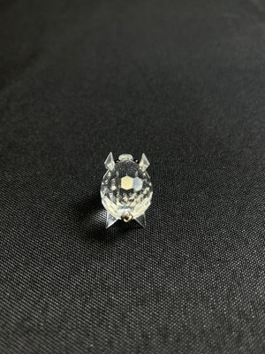 Small round object with a textured surface on a black fabric background