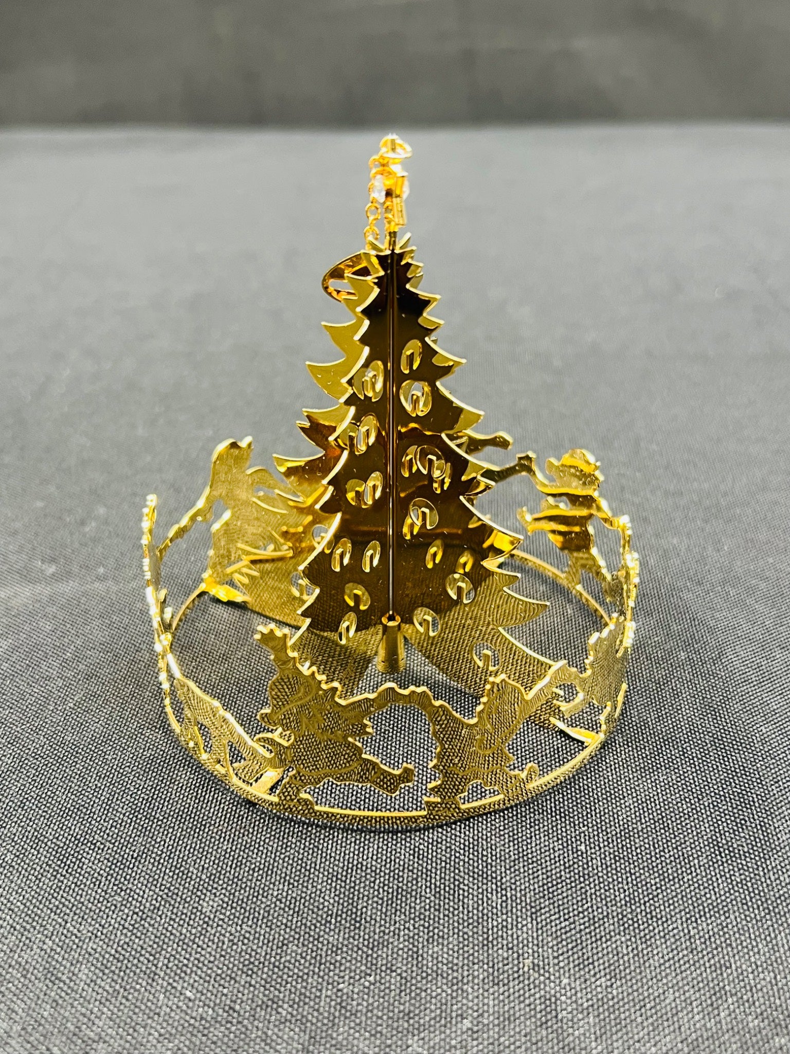Gold metal Christmas tree decoration on a gray background