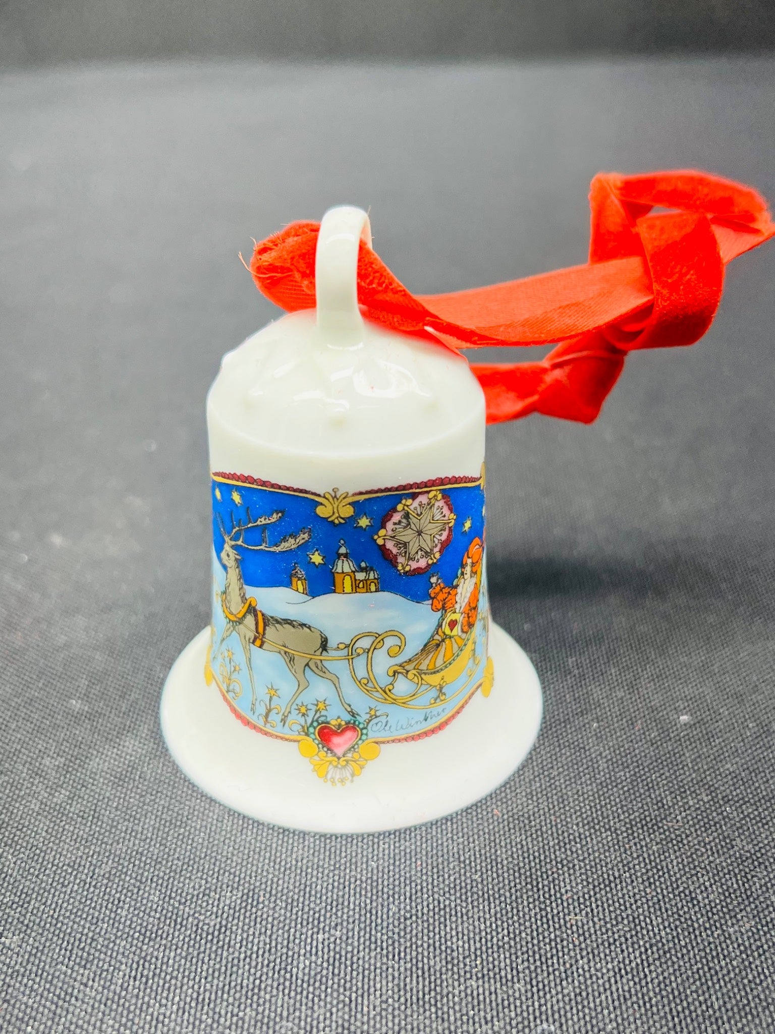 Decorative Christmas bell with festive design and red ribbon on a gray background