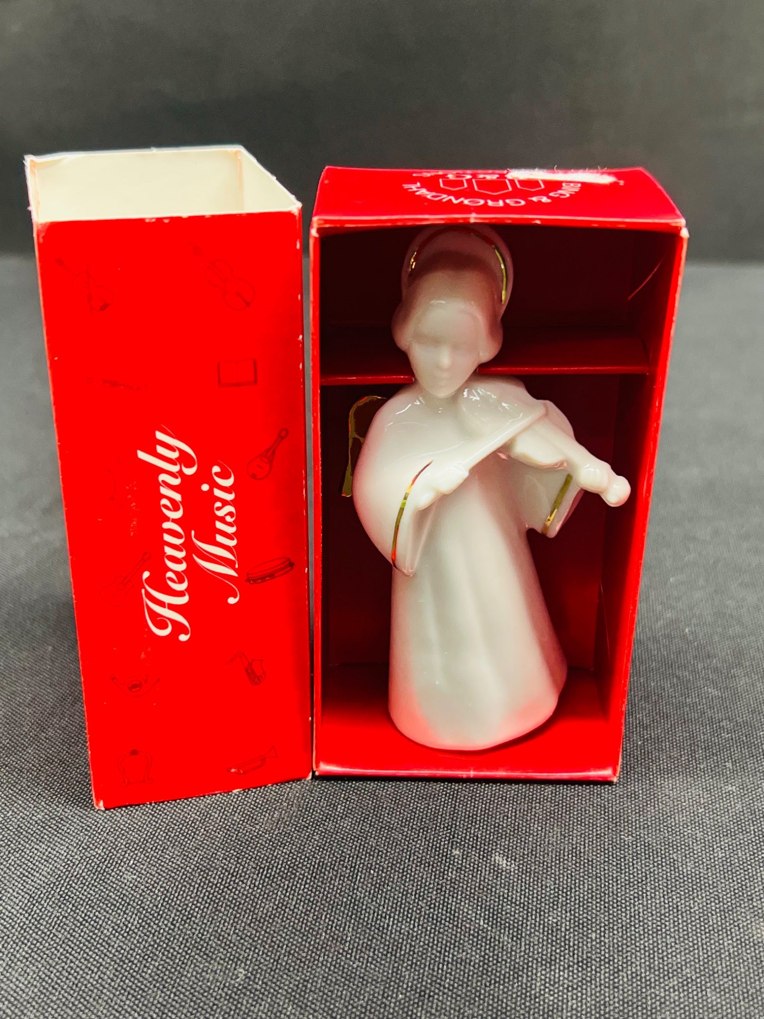 Decorative angel figurine in a red box with 'Heavenly Music' text on a gray background
