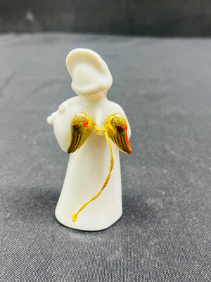 White angel figurine with gold wings on a gray background