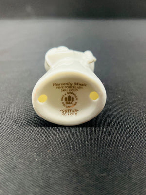 Small white figurine with 'Heavenly Music' branding on a dark textured background