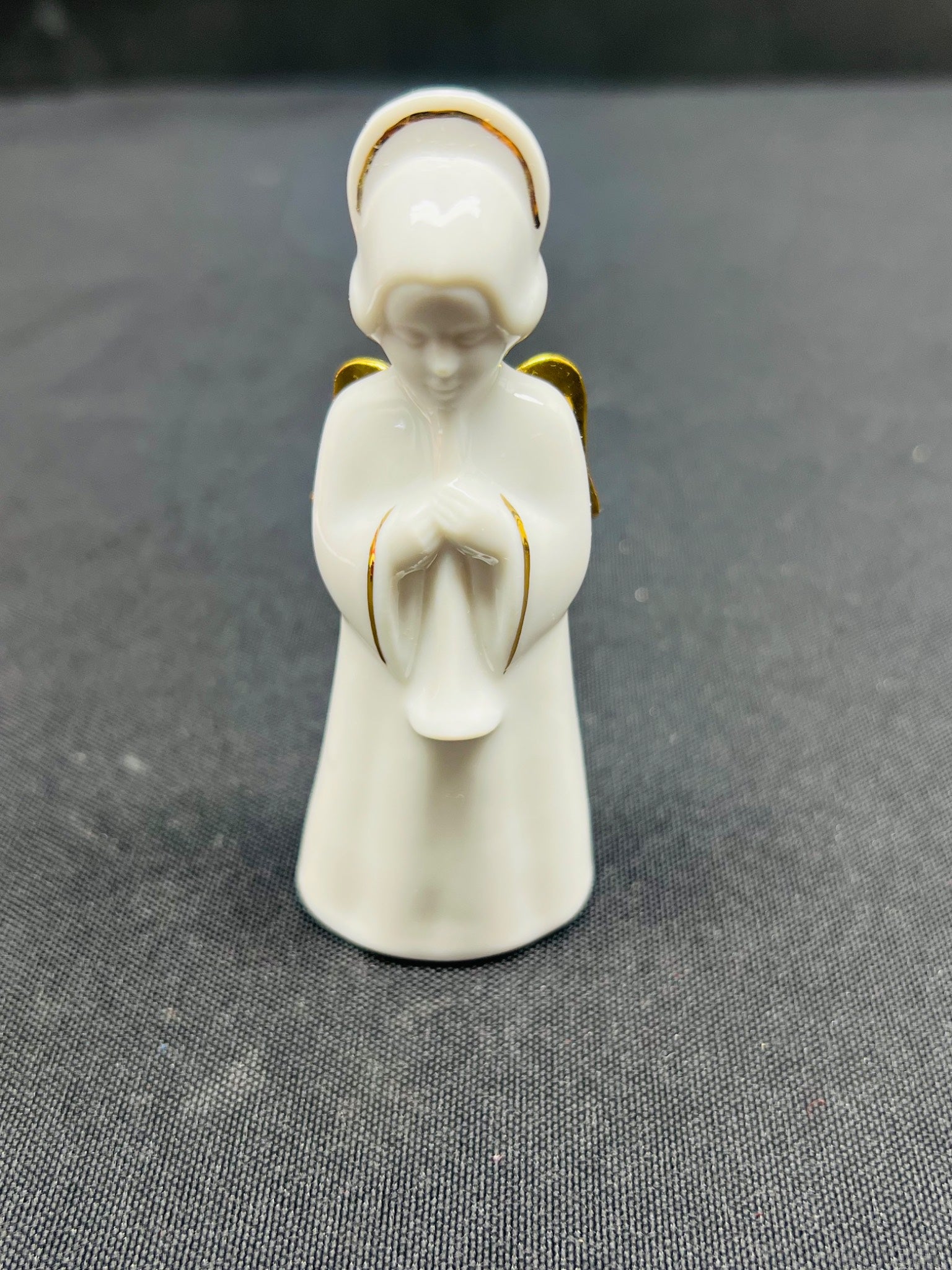 White ceramic angel figurine on a gray surface