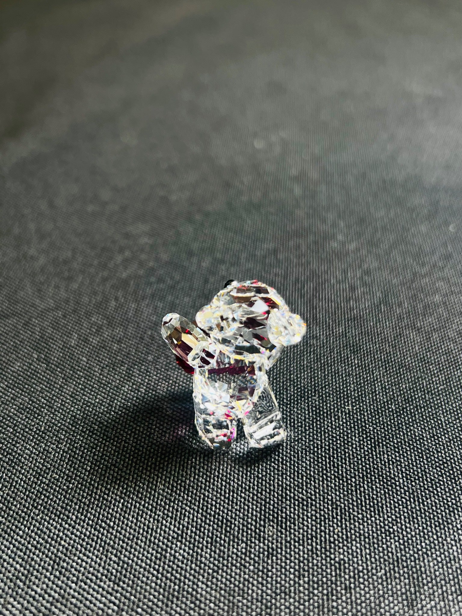 Crystal dog figurine on a textured gray surface