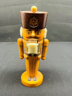 Wooden nutcracker figure on a gray background