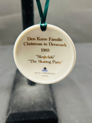 Round ceramic ornament with text and Royal Copenhagen logo on a plain background