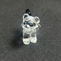 Clear glass bear figurine on a dark textured surface