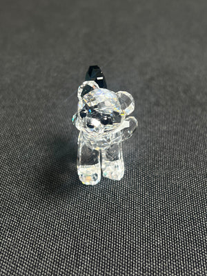 Clear glass bear figurine on a dark textured surface