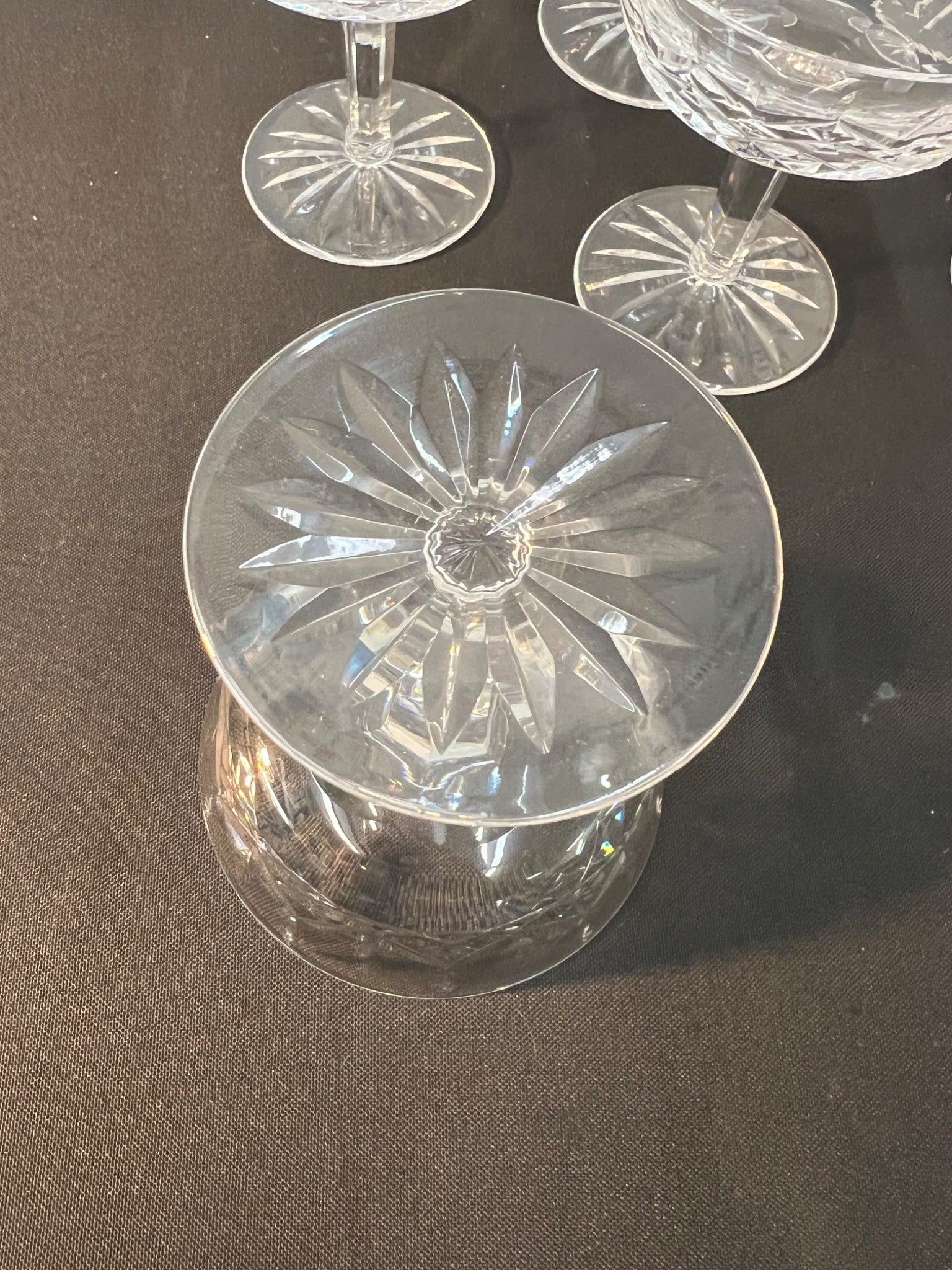 Clear glass coupe with starburst pattern on a dark surface