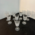 Set of crystal glasses on a dark surface with a white wall background