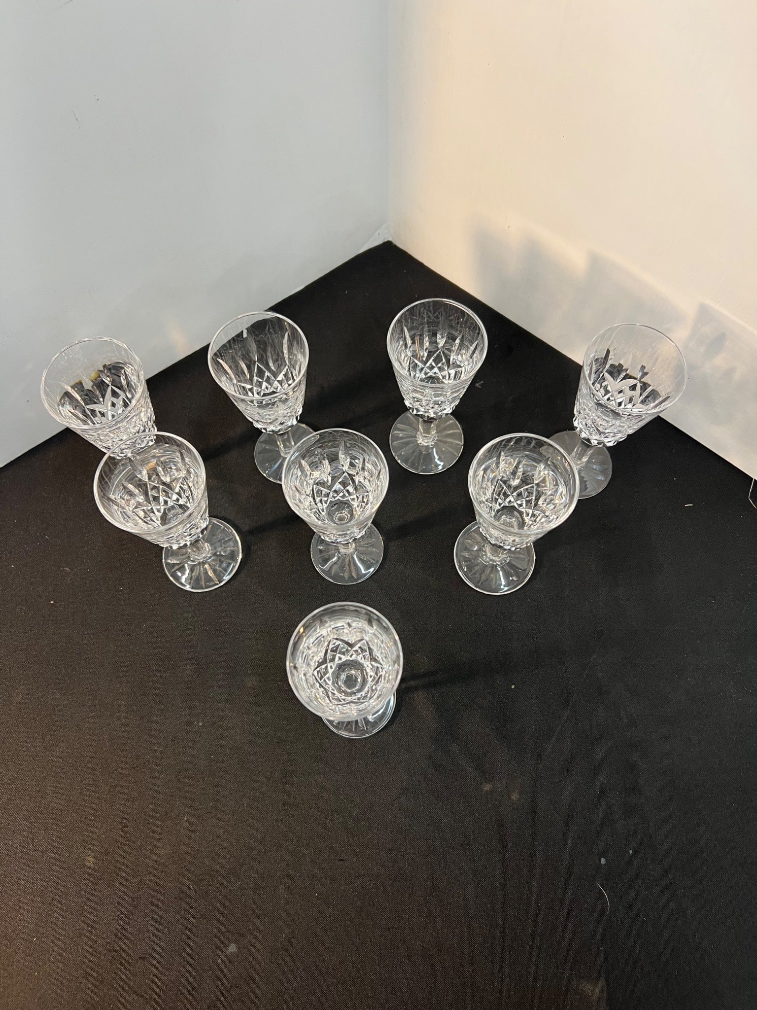 Set of clear glass goblets on a dark surface with a light gray background