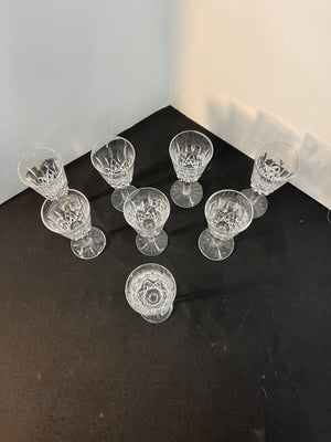 Set of clear glass goblets on a dark surface with a light gray background