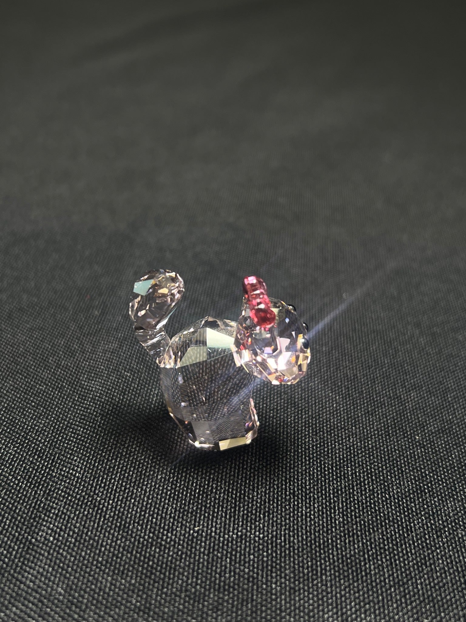 Crystal dog figurine on a dark fabric background