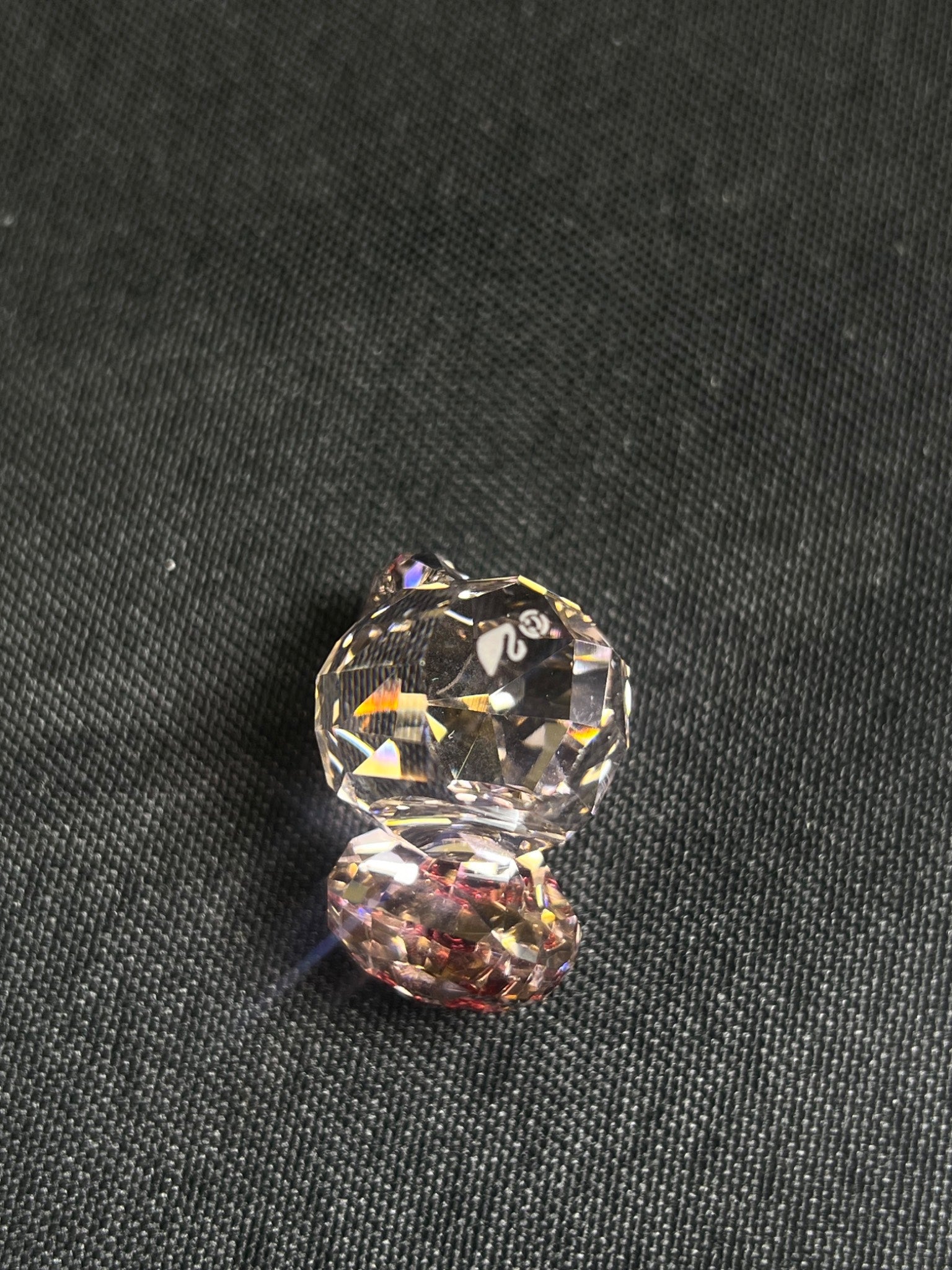 Two crystal beads on a dark fabric background