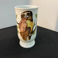 White ceramic cup with an owl design on a black surface