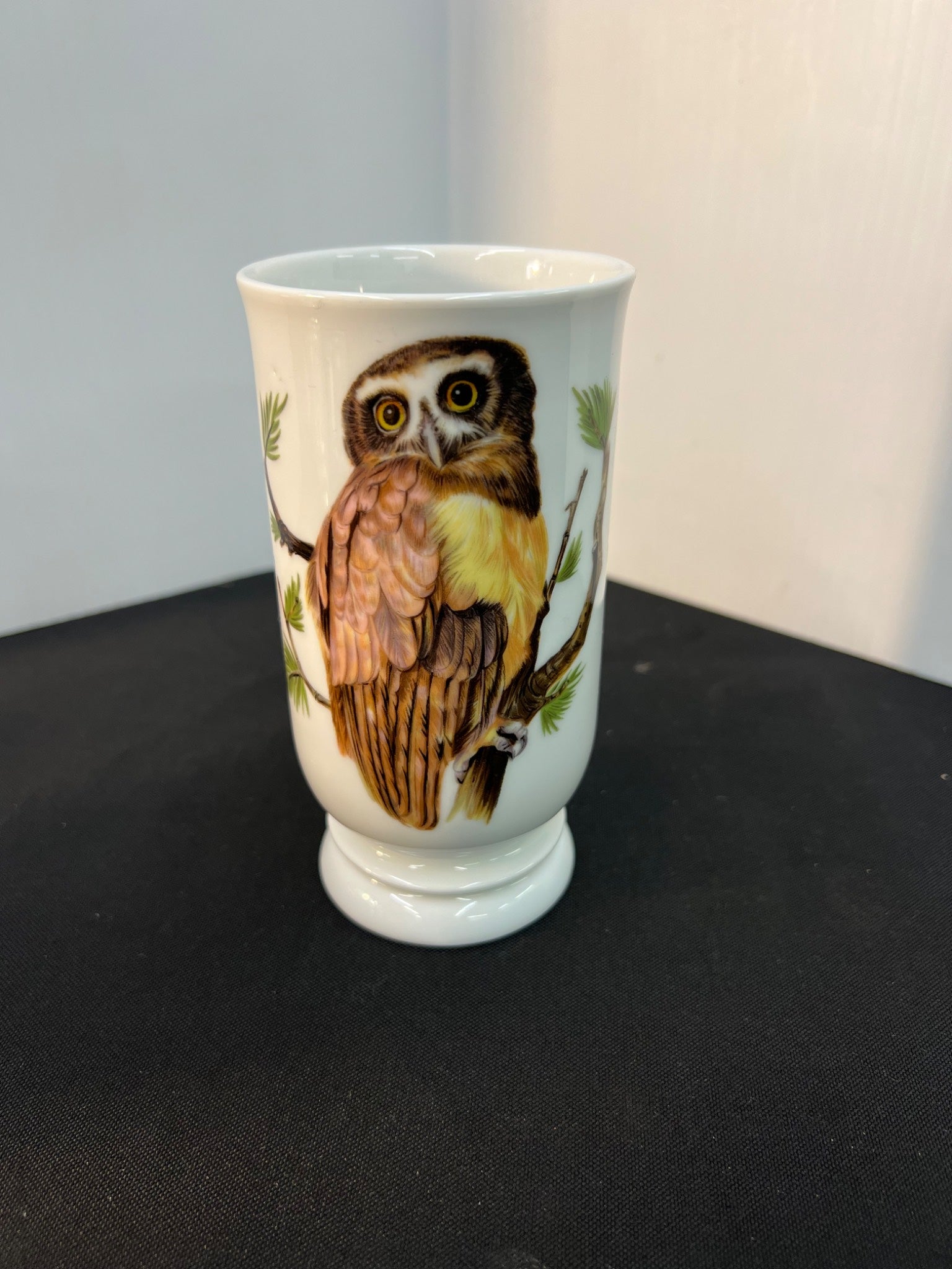 White ceramic cup with an owl design on a black surface