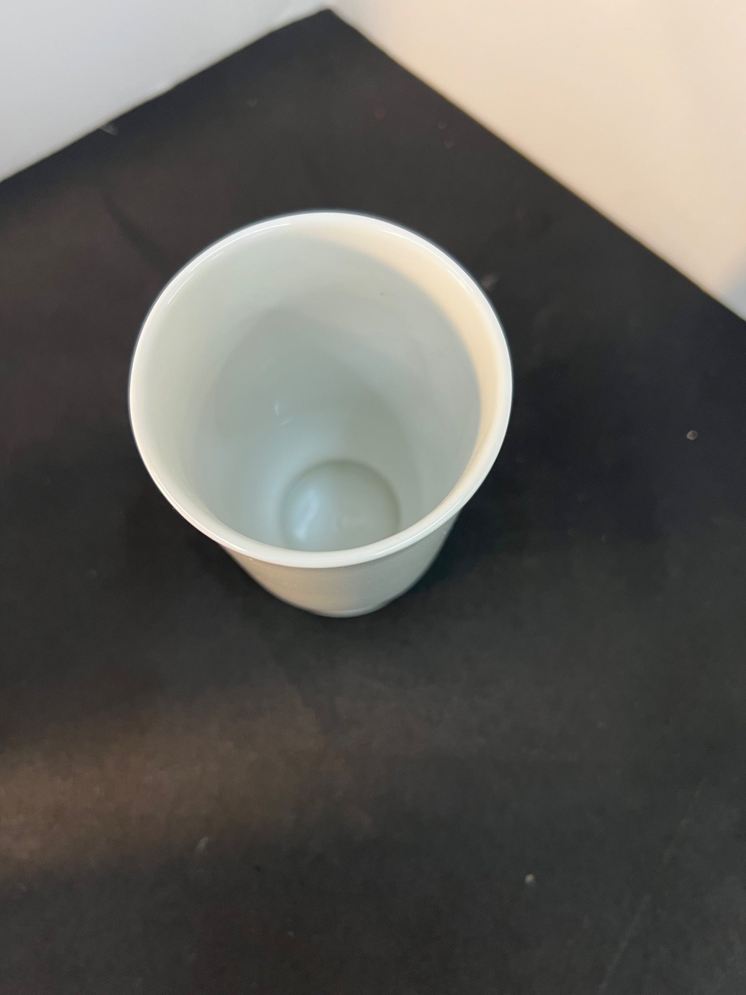 White ceramic cup on a black surface