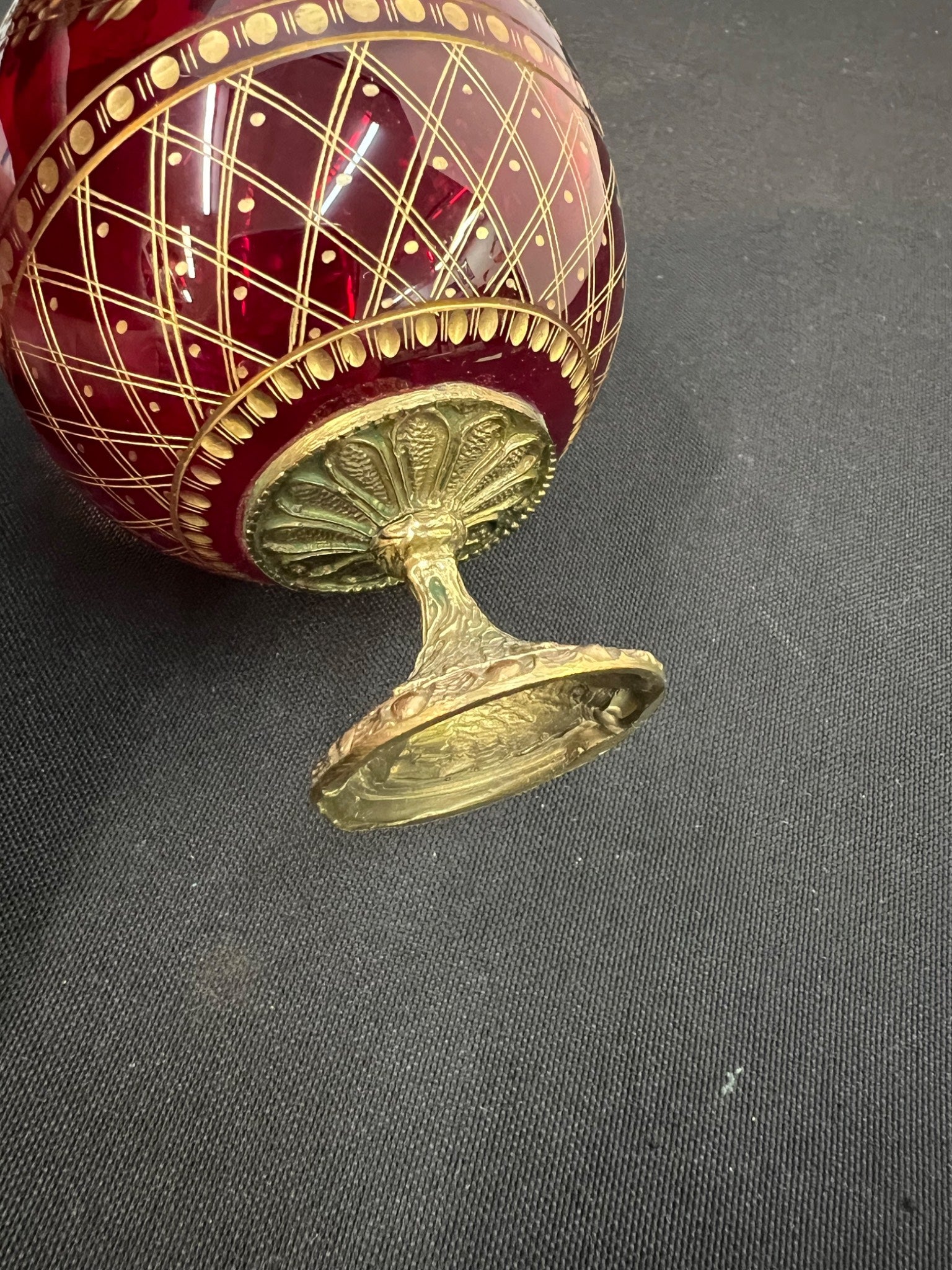 Decorative red and gold egg on a dark fabric background