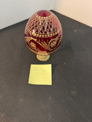 Decorative red egg with gold patterns on a black surface
