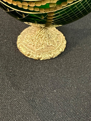Close-up of a gold decorative element on a green textured surface