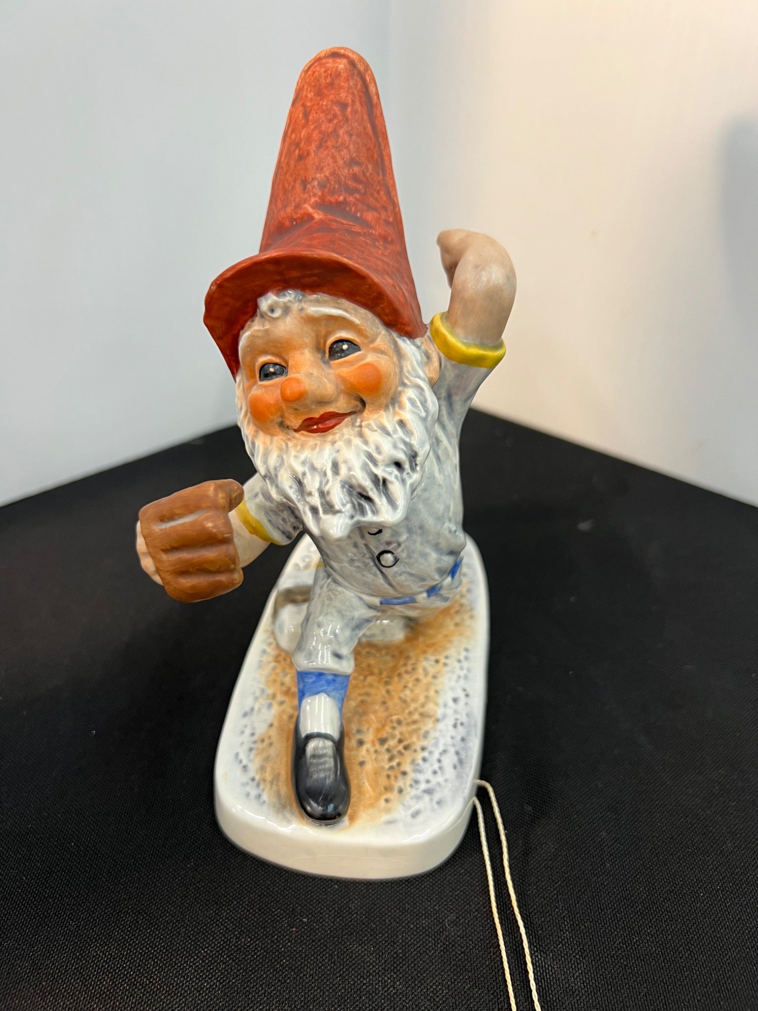 Gnome figurine with a red hat and beard on a black surface