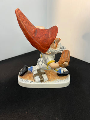 Gnome figurine with a red hat and a bag on a black surface