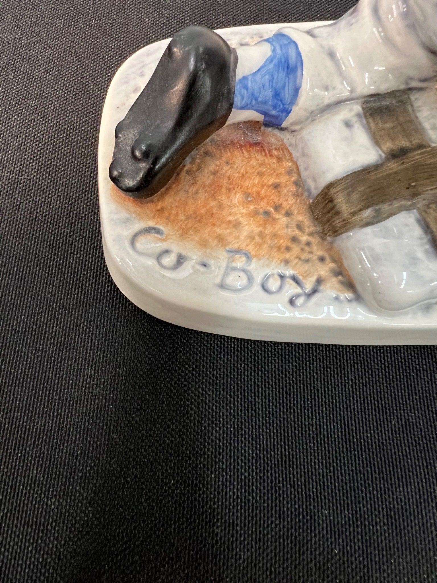 Decorative boot with horse figure and 'Co-Boys' branding on a dark background