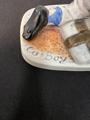 Decorative boot with horse figure and 'Co-Boys' branding on a dark background