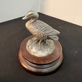 Decorative metal duck figure on a wooden base