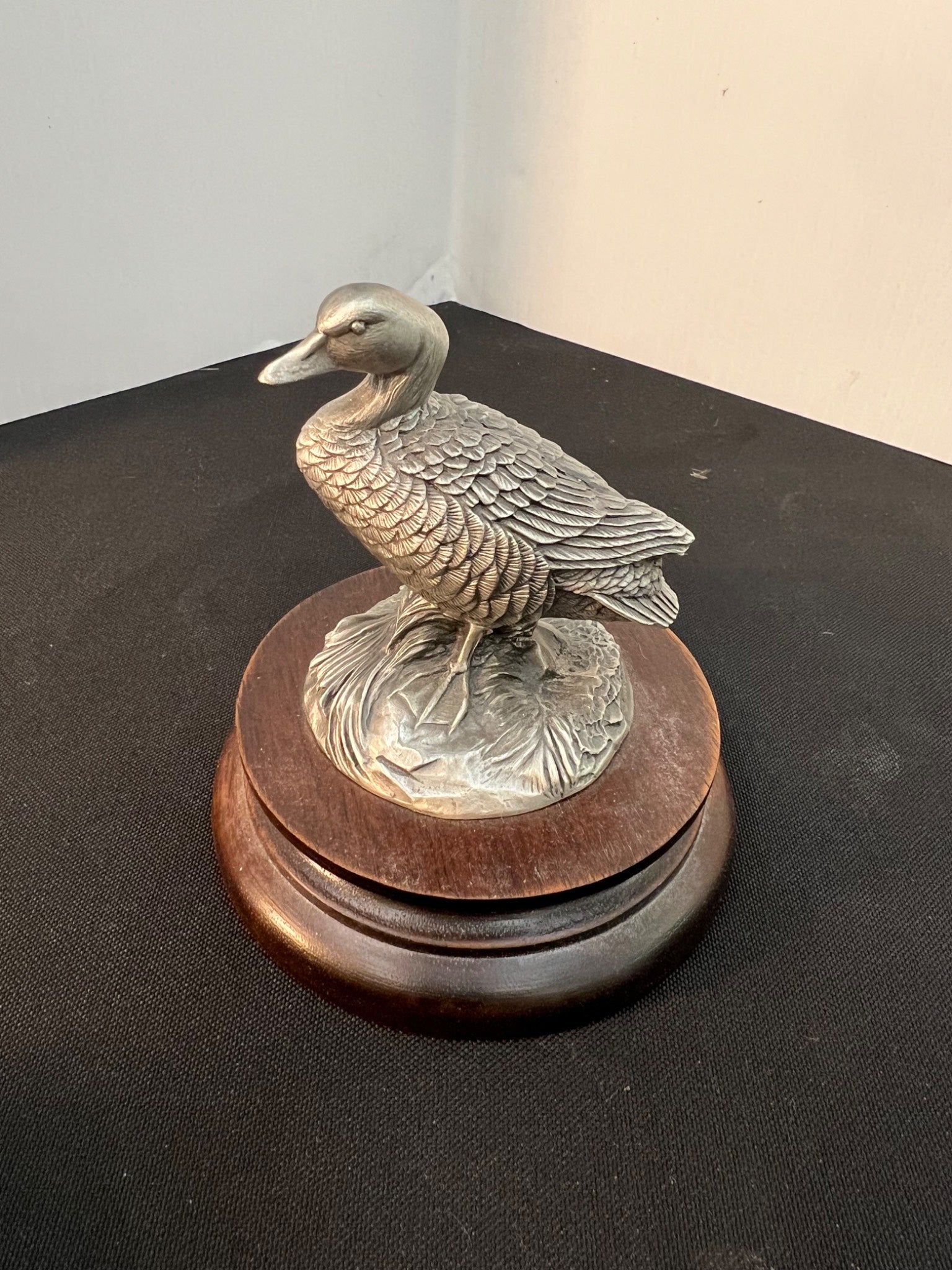 Decorative metal duck figure on a wooden base