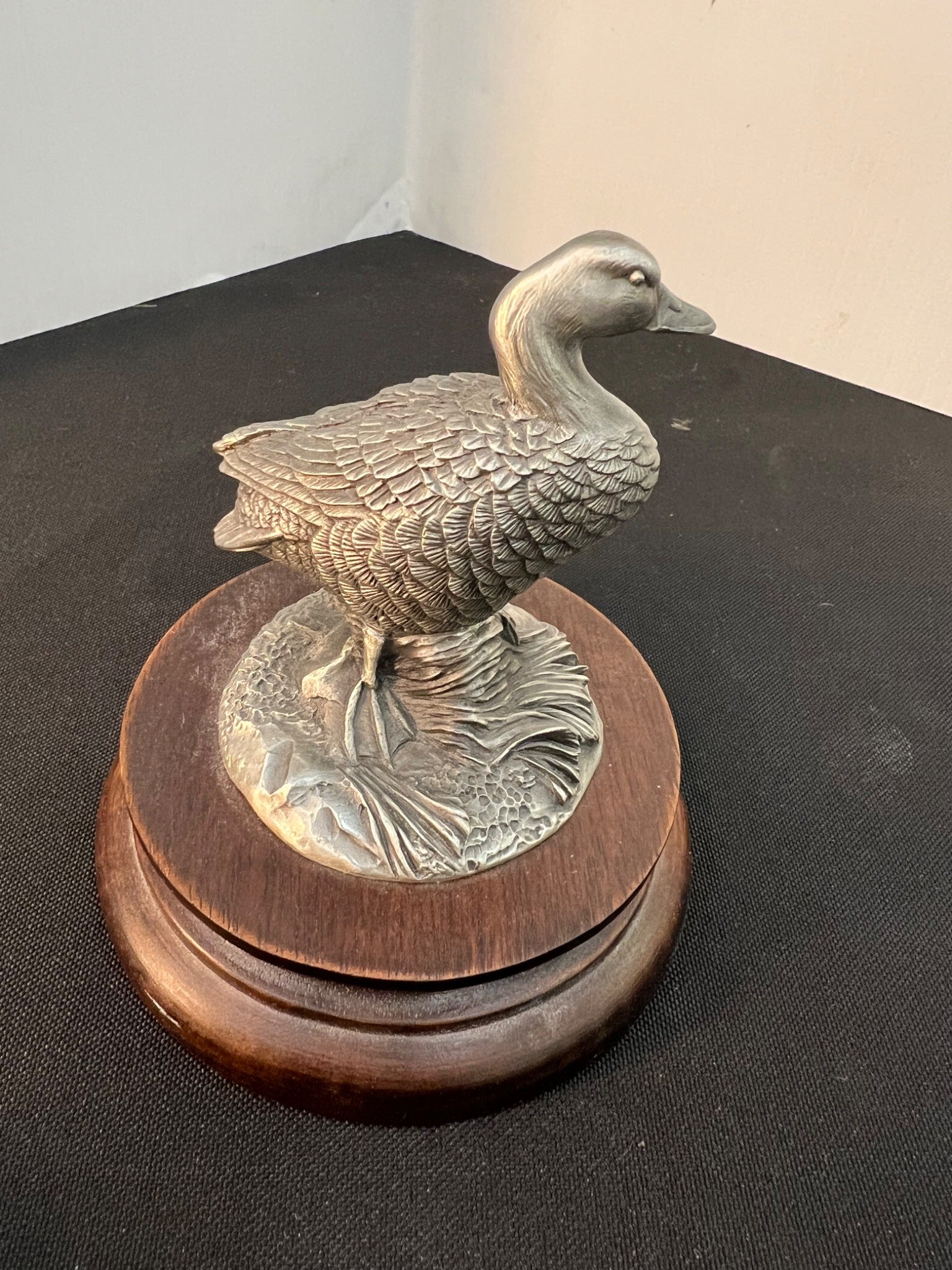 Metallic duck sculpture on a wooden base