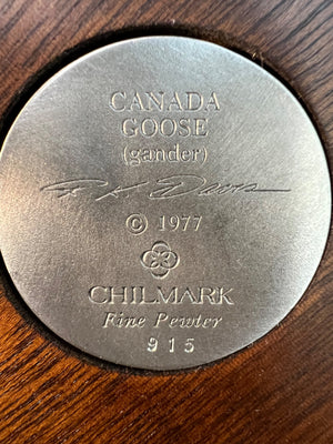 Round metal stamp with 'Canada Goose' and 'Chilmark' branding on a wooden surface