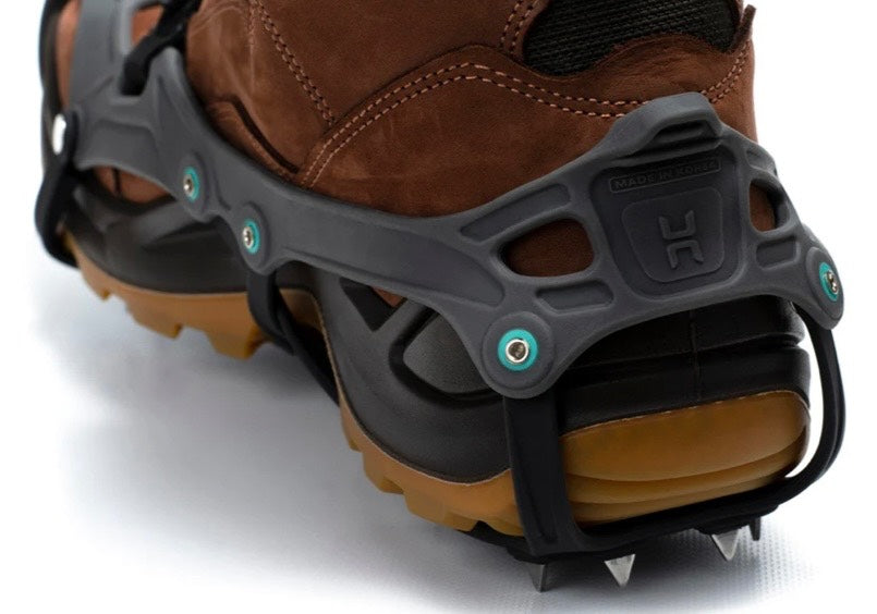 Brown boot with black crampon attachment on a white background