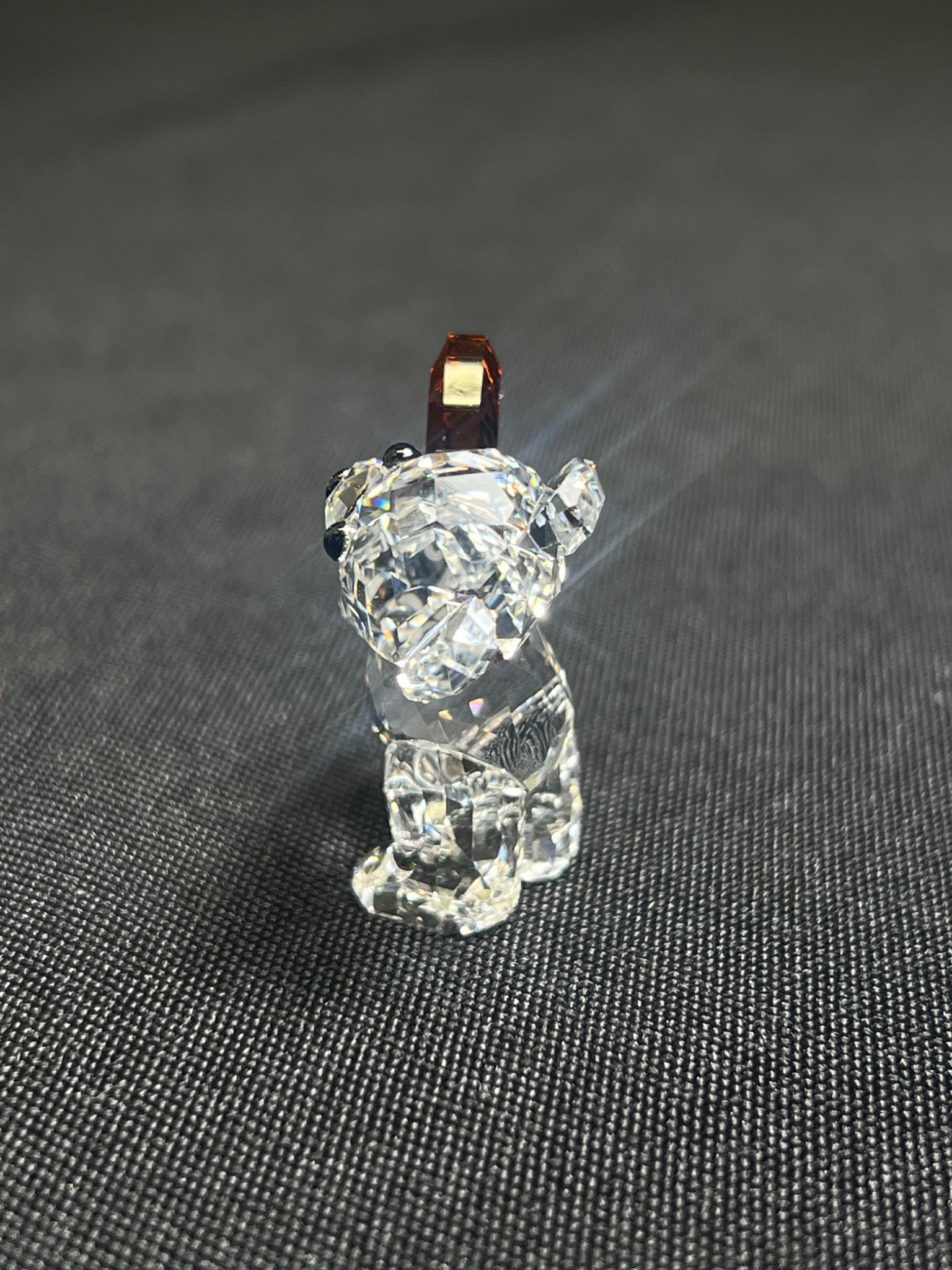 Clear crystal bear figurine on a dark textured surface