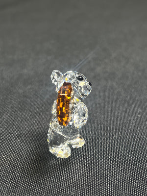 Crystal bear figurine with a brown center on a dark textured background