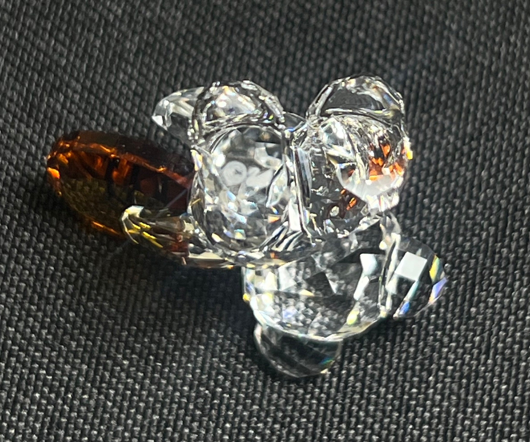 Clear crystal flower-shaped object on a textured black surface