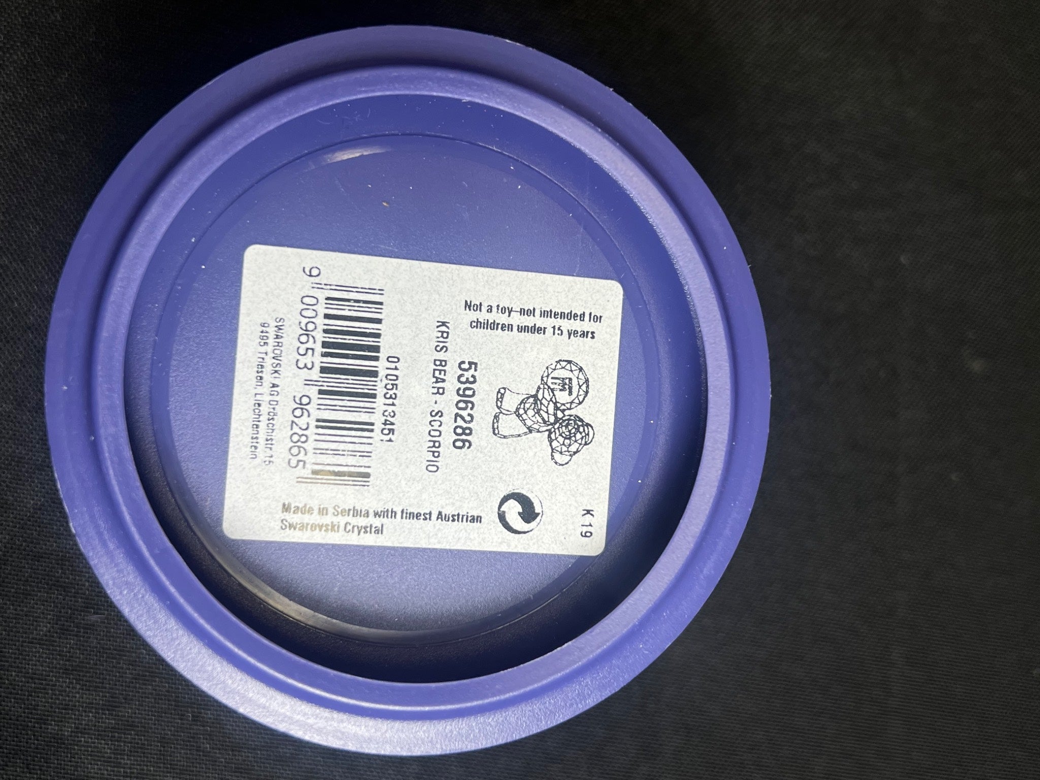 Purple lid with a label on a black background